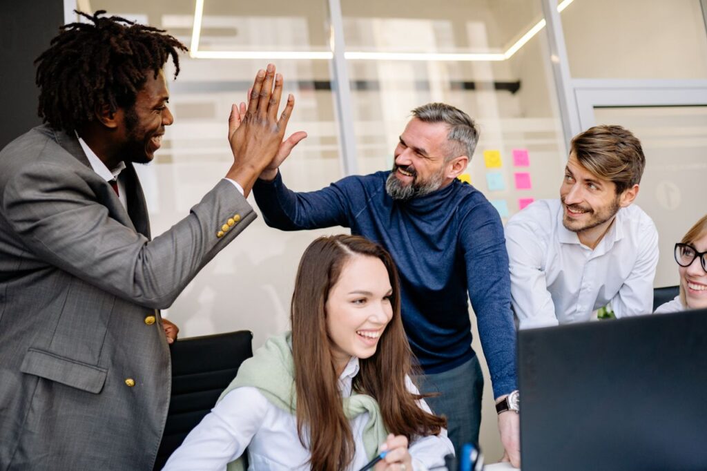 pexels-photo-7794041-7794041 A diverse team happily celebrates a workplace achievement with high-fives.